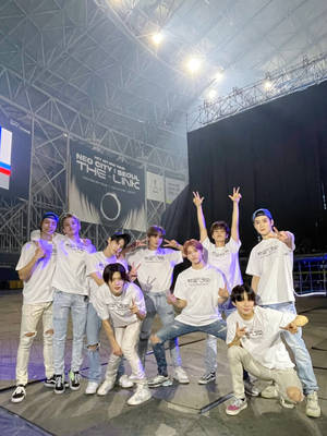 K-pop團體在演唱會期間穿著白色T恤在舞台上擺姿勢。 — Nct 127 壁紙