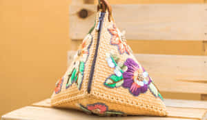 一個色彩繽紛的刺繡草袋放在木長椅上。 — 刃牙 壁紙
