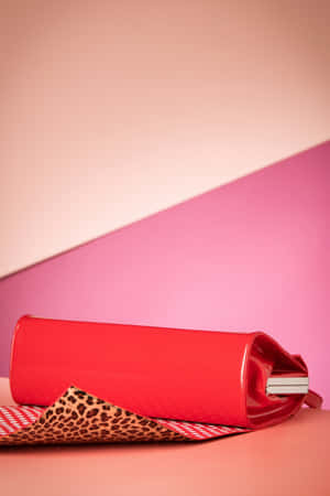 豹紋布料上的紅色手拿包，粉紅色和蜜桃色背景。 — 2:3 壁紙