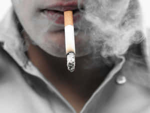 一個人吸煙，煙霧從點燃的一端升起。 — 煙動圖 壁紙