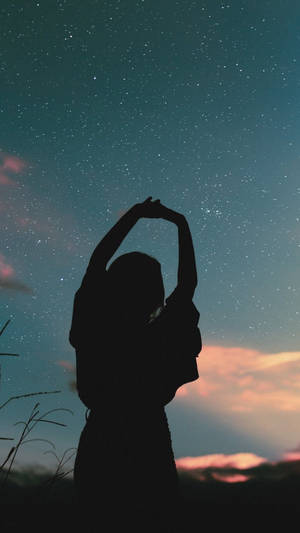 一個人在暮色中於星空下伸展雙臂 — 暗黑少女風 壁紙