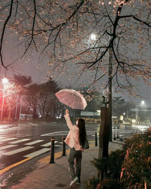 雨夜人行道上，人在櫻花下拿著粉紅雨傘。 — 垃圾美學 壁紙