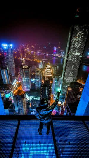 夜晚在玻璃陽台上俯瞰發光城市的人 — 電馭叛客2077 壁紙