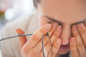 人拿著眼鏡同時用手指按壓眼睛 — 眼睛 壁紙