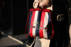 在城市環境中，一個人拿著Gucci條紋束繩袋。 — Gucci GIF 壁紙