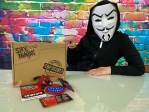 戴面具的小孩在桌上展示 Spy Ninjas 玩具，背景是色彩繽紛的磚牆。 — 間諜忍者 壁紙