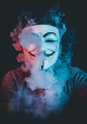 戴白色面具的人在黑暗環境中呼出彩色煙霧 — 駭客面具 壁紙