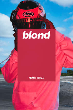 穿著紅色賽車裝備的人舉起Frank Ocean的「blond」專輯封面。 — Frank Ocean 動圖 壁紙