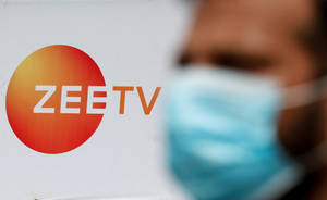 一個戴著藍色口罩的人站在Zee TV標誌附近。 — 標誌 壁紙