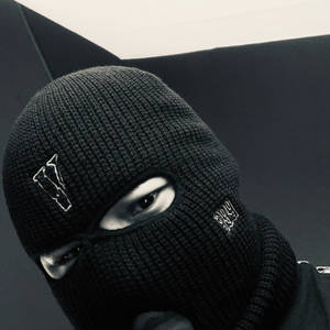 戴黑色巴拉克拉法帽、有白色標誌的人在黑暗環境中強烈凝視 — Vlone 壁紙