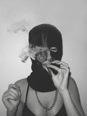 戴黑色頭套的人吸煙，煙霧在臉周圍縈繞。 — 社群媒體 壁紙