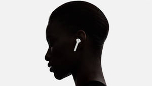 一個人戴著白色無線耳機的側面剪影。 — AirPods 壁紙