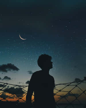 夜晚站立，抬頭仰望星星與彎月的人。 — 城市燈光 壁紙