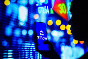 一個人拿著一部有Zillow應用程式的電話，背景是發光的股票市場。 — 霓虹手機 壁紙