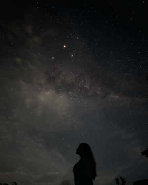 一個人在銀河可見的星空下敬畏地站立。 — 星星 壁紙