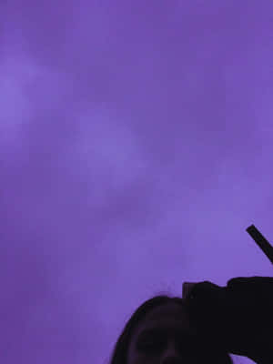 一個人仰望帶有雲朵的紫色暮色天空。 — 可愛的悲傷 壁紙