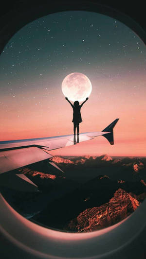 夜晚站在飛機機翼上伸手觸及山脈上方的月亮的人。 — 高畫質月亮 壁紙
