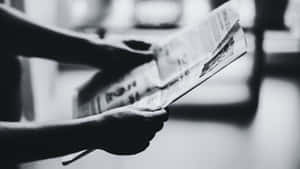 黑白特寫雙手翻閱報紙。 — Old Paper 壁紙