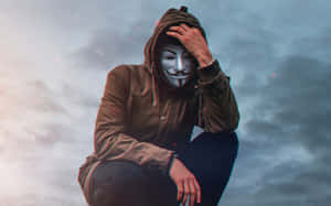 戴著蓋伊·福克斯面具的人蹲在黃昏的多雲天空中。 — 駭客面具 壁紙