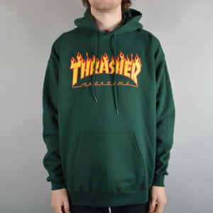 穿著綠色連帽上衣的人，帶有橙色火焰風格Thrasher Magazine標誌。 — Thrasher 壁紙