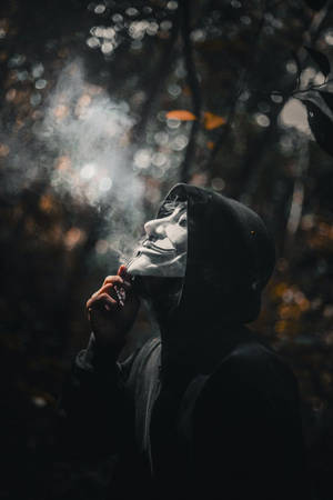 戴著蓋伊·福克斯面具的人在黑暗的森林中吸煙 — 抽菸 壁紙