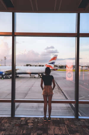暮色中透過機場窗戶觀看英國航空飛機的人。 — 機場 壁紙