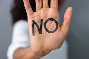 手掌上寫著「NO」的手，用以表示拒絕或停止。 — 黑人女性 壁紙