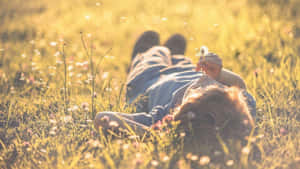 在溫暖陽光下躺在草地上手持蒲公英的人 — 蒲公英 壁紙