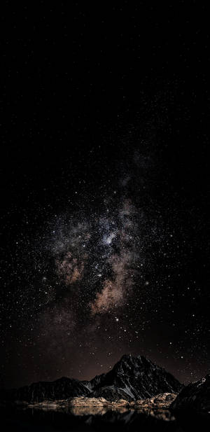 銀河系在黑暗山脈上方，倒映在夜晚的靜止水面 — 星星 壁紙