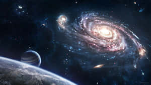 一個帶有粉紅色和藍色色調的螺旋星系主導了宇宙場景，附近有一顆行星和衛星。 — 午夜 壁紙