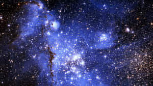 一個宇宙星雲，充滿了發光的藍色雲朵和閃爍的星星。 — 星星 壁紙