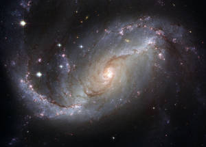 一個螺旋星系，在深空中擁有發光的臂和明亮的恆星。 — 酷炫星系 壁紙