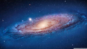 一個螺旋星系，在深藍色宇宙背景中有發光的旋臂和星星。 — 宇宙 壁紙