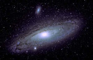 一個螺旋星系，具有明亮的核心和充滿恆星和宇宙塵埃的旋轉臂。 — 4K 光環 壁紙