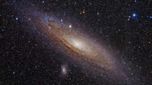 一個在深空中擁有發光旋臂和無數恆星的螺旋星系。 — 16:9 壁紙