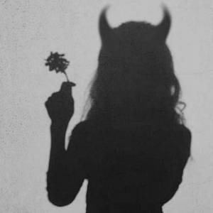 一個帶角的人物手持花朵，背景是紋理牆壁的剪影。 — 仙女美學 壁紙