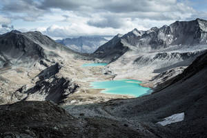 陰天下，岩石山脈山谷中的碧綠色湖泊。