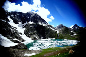一個高海拔山湖，有正在融化的冰和白雪覆蓋的山峰，在明亮的藍天下。 — 湖泊 壁紙