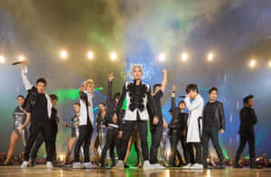 K-pop團體在燈光、煙霧和舞者的舞台上表演。 — 大爆炸理論 壁紙