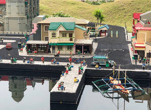 LEGO小鎮，建築物和人們在靠近海濱的地方，附近有一艘船。 — 樂高旋風忍者 壁紙