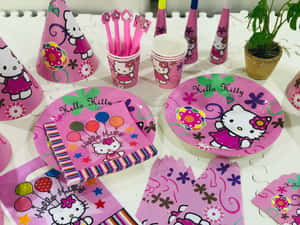 Hello Kitty派對用品，包括盤子、杯子、帽子和餐巾，放在白色桌子上。 — 凱蒂貓 美學 GIF 壁紙