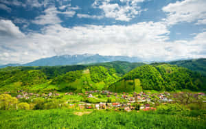 綠色山谷中的村莊，有山脈和藍天 — 山坡 壁紙