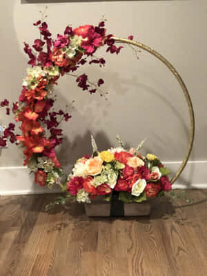 在木地板上，金色圓環和木箱中的彩色花卉展示。 — 2048x2732 壁紙