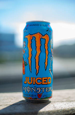 一個藍色Monster Energy飲料罐（芒果味）在明亮陽光下放在混凝土上。 — 榮耀MagicPad4 壁紙