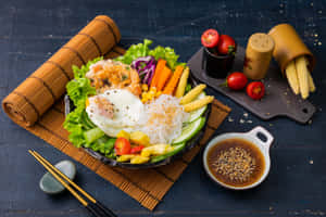 色彩繽紛的韓式拌飯，配有雞蛋、玉米和蔬菜，放在竹蓆上，附有沾醬。 — MacBook Air 15 壁紙