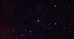 一個角落有微弱紅色星雲光芒的星空夜晚。 — 宇宙美學 壁紙