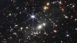 深空視圖，顯示星系和恆星，帶有鏡頭光暈。 — 太空 壁紙