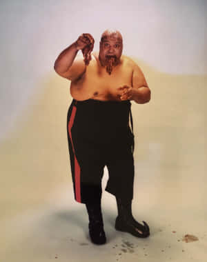 一個穿著帶有紅色條紋黑色褲子的男人正在吃肉，醬汁從他的嘴裡滴下來。 — 摔角 壁紙