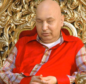 一個光頭男人穿著紅色背心在華麗的金色王座上睡覺。 — 老師 壁紙