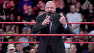 摔角手穿著西裝在場內拿著WWE麥克風指向人群 — WWE GIF 壁紙